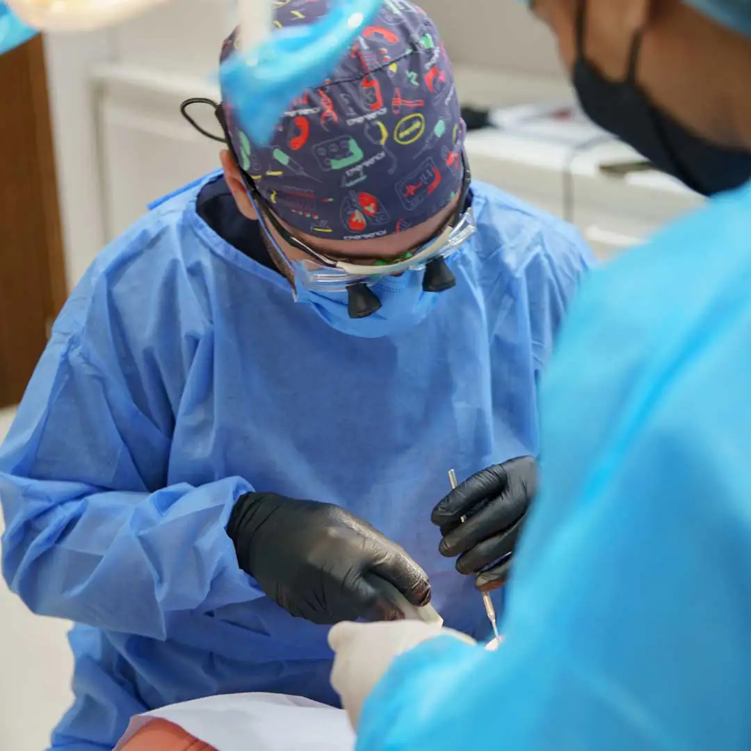 Specialist periodontist at Harmony Medical Center performing gum depigmentation treatment on a patient