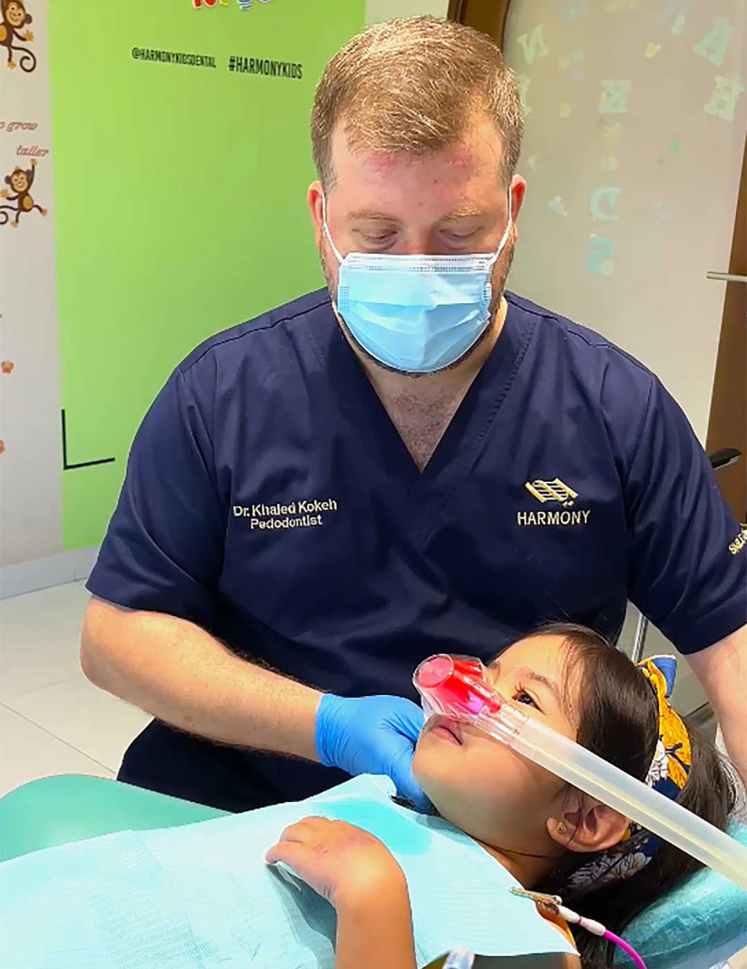 Dr. Khaled Kokeh, pediatric dentist at Harmony, performing dental treatment on a young patient under laughing gas sedation.